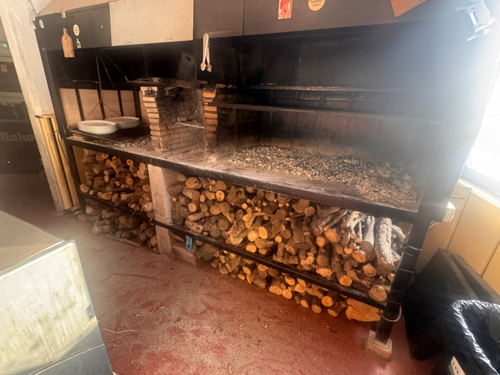 Reparto de leña de olivo para la brasa de un restaurante